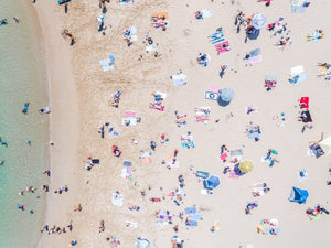 Aerial topdown of colorful people tanning by the sea at the beach in Sydney