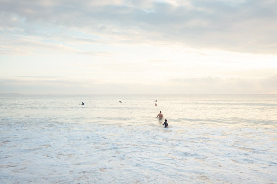 Neutral surfers lined up in water for sunrise surf on Manly Beach Sydney