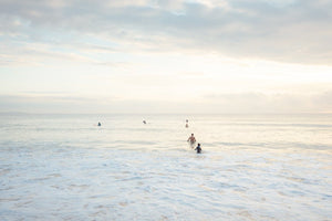 Neutral surfers lined up in water for sunrise surf on Manly Beach Sydney