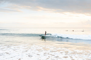 Girl surfing on a wave during sunrise on Manly Beach in Sydney