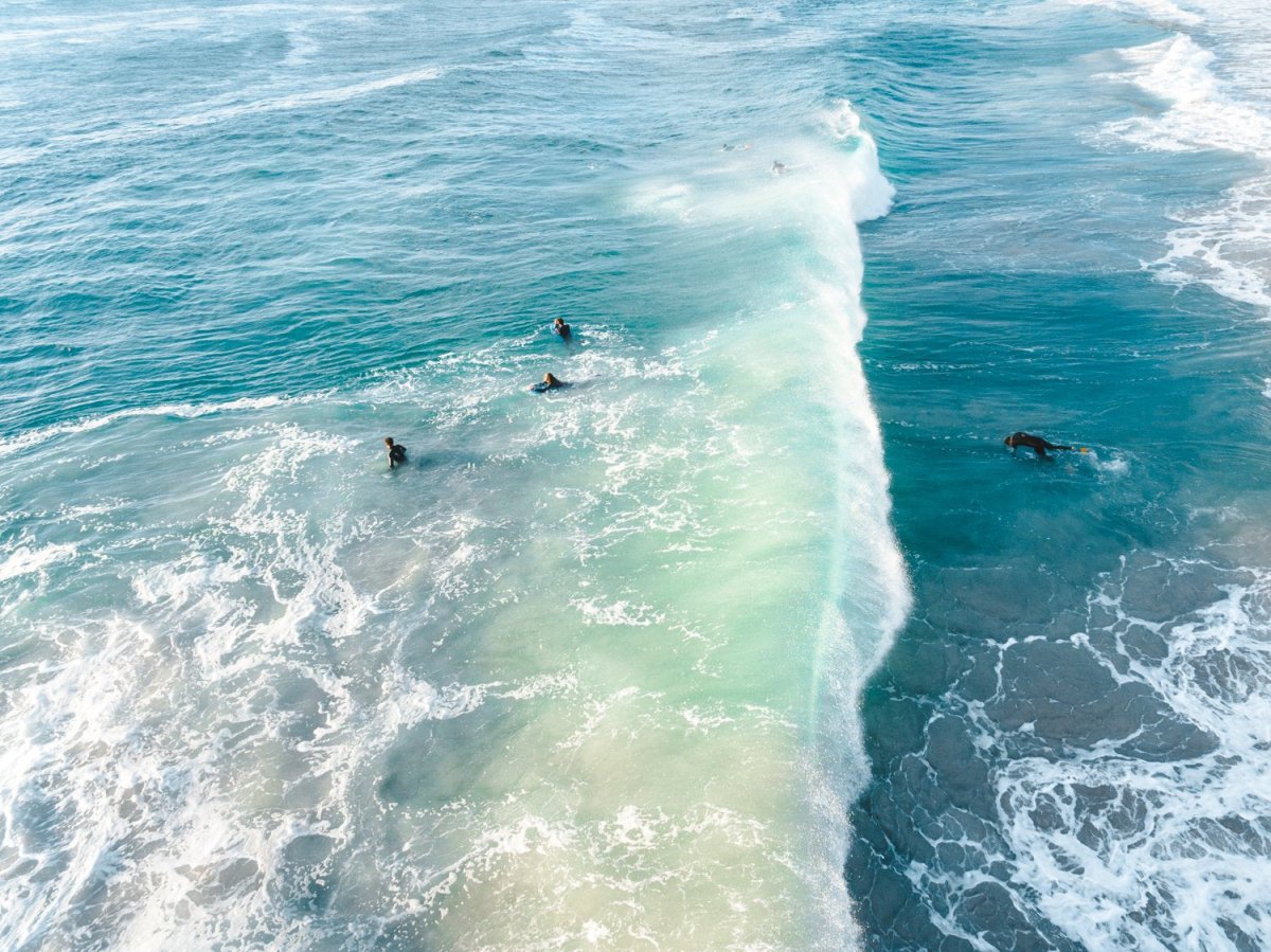 Wave crashing over surfer from above in Sandy Bay beach Cape Town