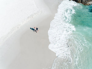 Aerial of a couple holding hands walking along Clifton Beach in Cape Town