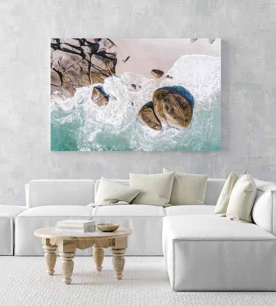 Girl standing among boulders on Clifton beach from above in a white fine art frame