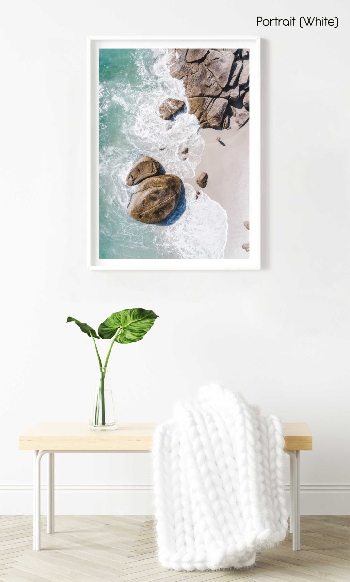 Girl standing among boulders on Clifton beach from above in a white fine art frame