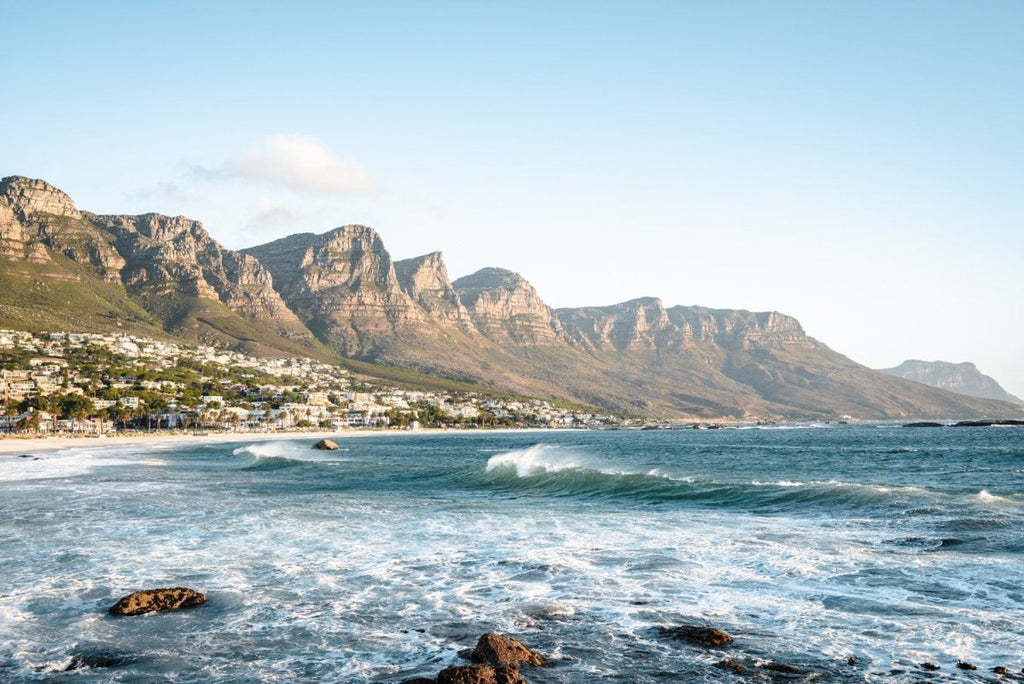 Windy offshore wave at Camps Bay Beach with Twelve Apostles mountains