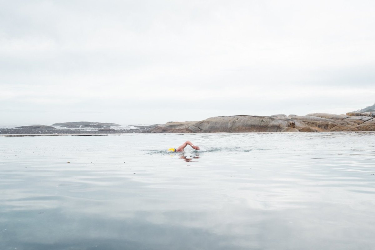 Man with yellow cap swimming in Camps Bay tidal pool