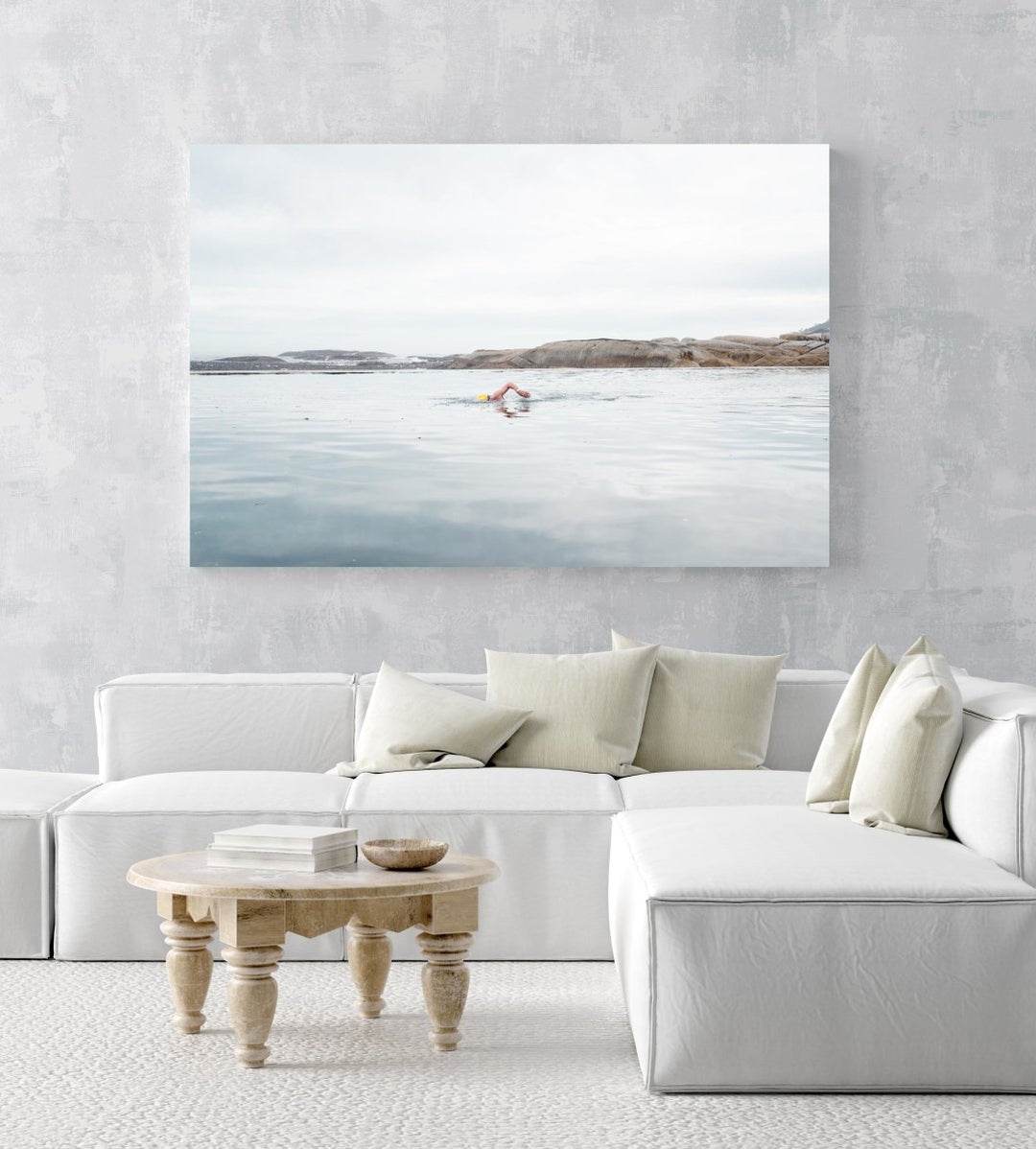 Man with yellow cap swimming in Camps Bay tidal pool in an acrylic/perspex frame