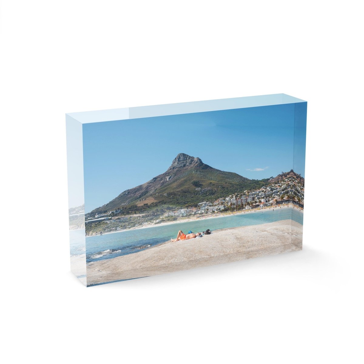 Old man lying on rock at Camps Bay beach below lions head