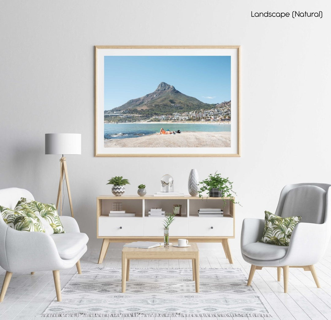 Old man lying on rock at Camps Bay beach below lions head in a natural fine art frame