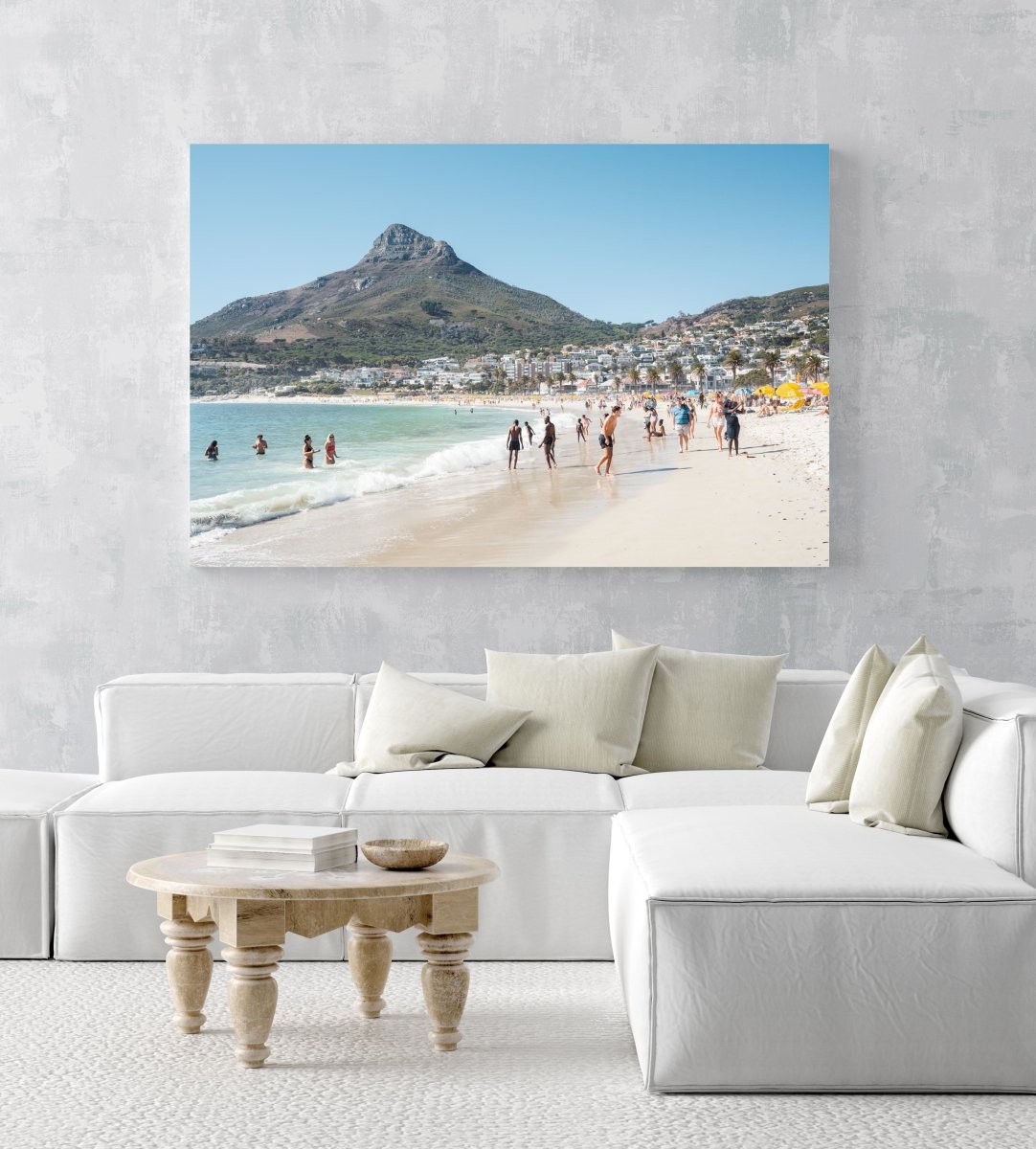 People swimming and playing on Camps Bay Beach below the lions head in an acrylic/perspex frame