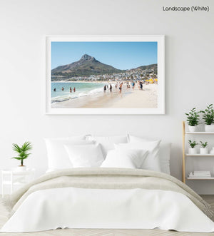 People swimming and playing on Camps Bay Beach below the lions head in a white fine art frame
