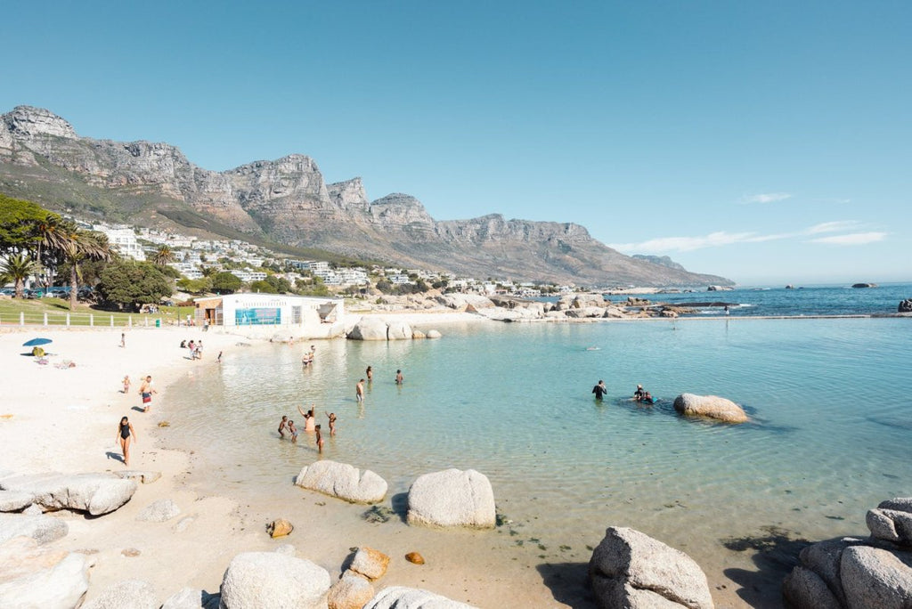 People swimming in the blue tidal pool in Camps Bay Cape Town
