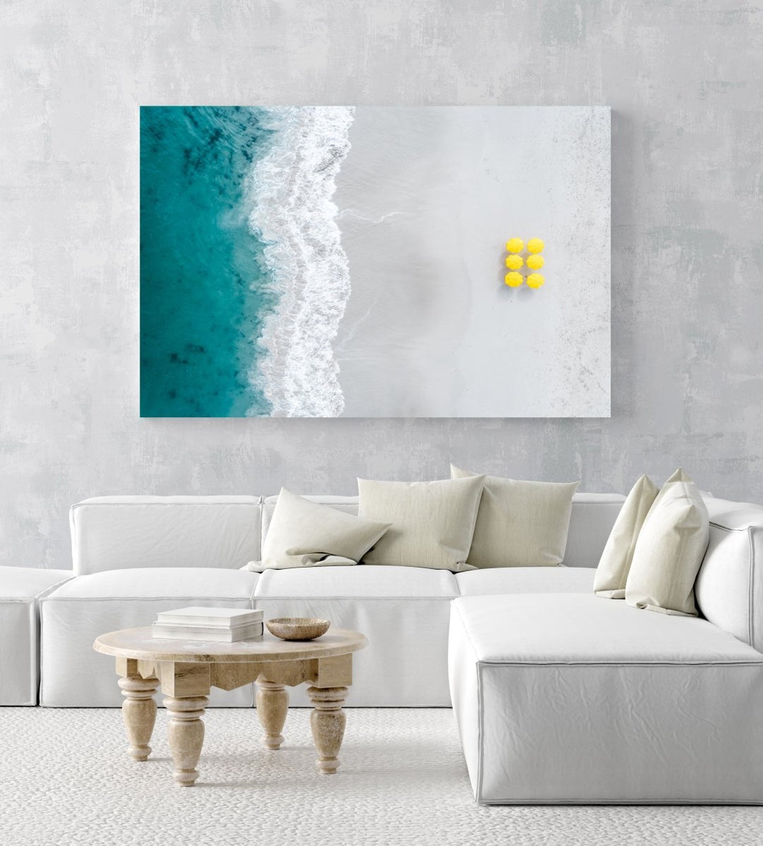 Aerial of six yellow umbrellas next to blue ocean on Camps Bay beach in Cape Town in a white fine art frame