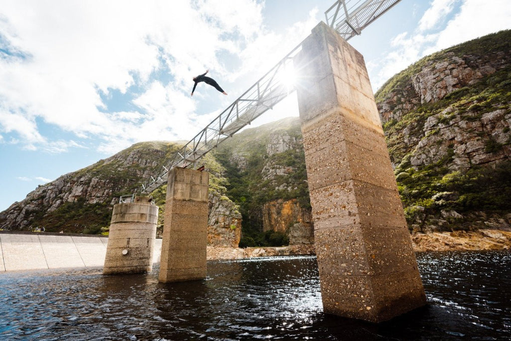 Boy doing a backflip off a bridge at Hermanus dams South Africa