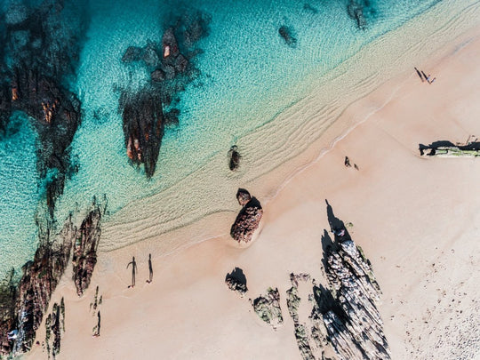 Aerial of kids playing on a beach in Kalk Bay