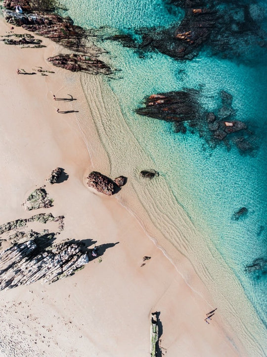 Aerial of kids playing on a beach in Kalk Bay