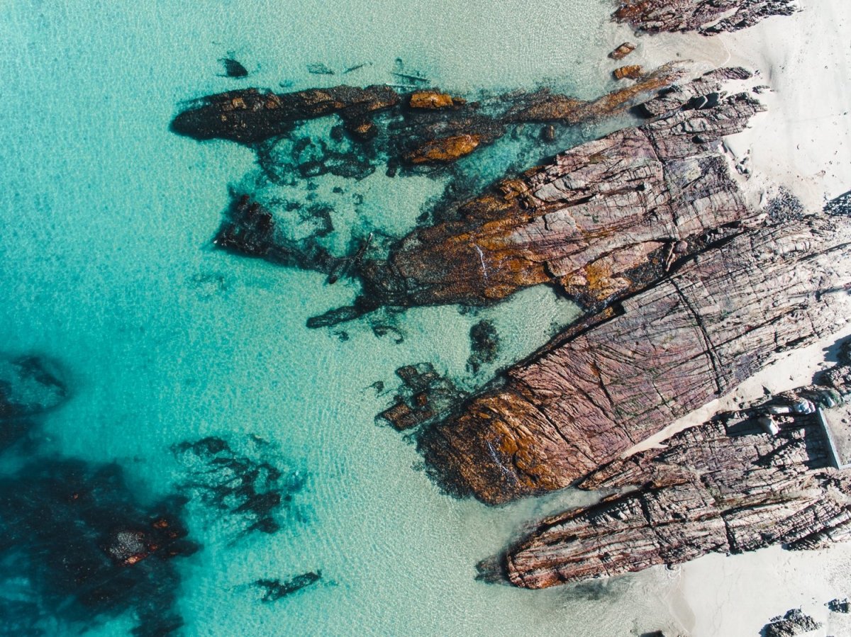 Rocks along the coast of Kalk Bay in blue calm water