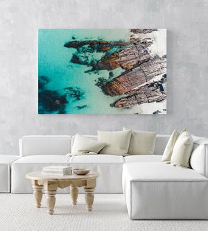 Rocks along the coast of Kalk Bay in blue calm water in a white fine art frame