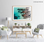 Rocks along the coast of Kalk Bay in blue calm water in a natural fine art frame