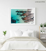 Rocks along the coast of Kalk Bay in blue calm water in a white fine art frame