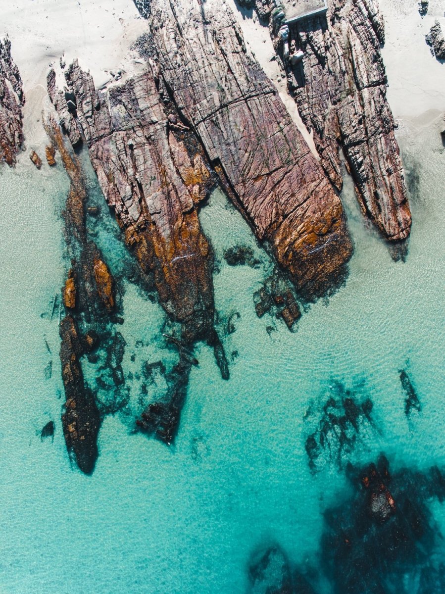 Rocks along the coast of Kalk Bay in blue calm water