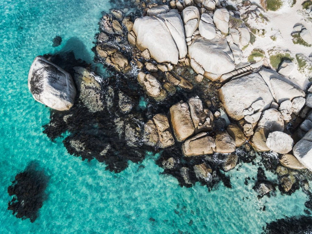 Aerial of boulders and blue sea along the coast of Simons Town