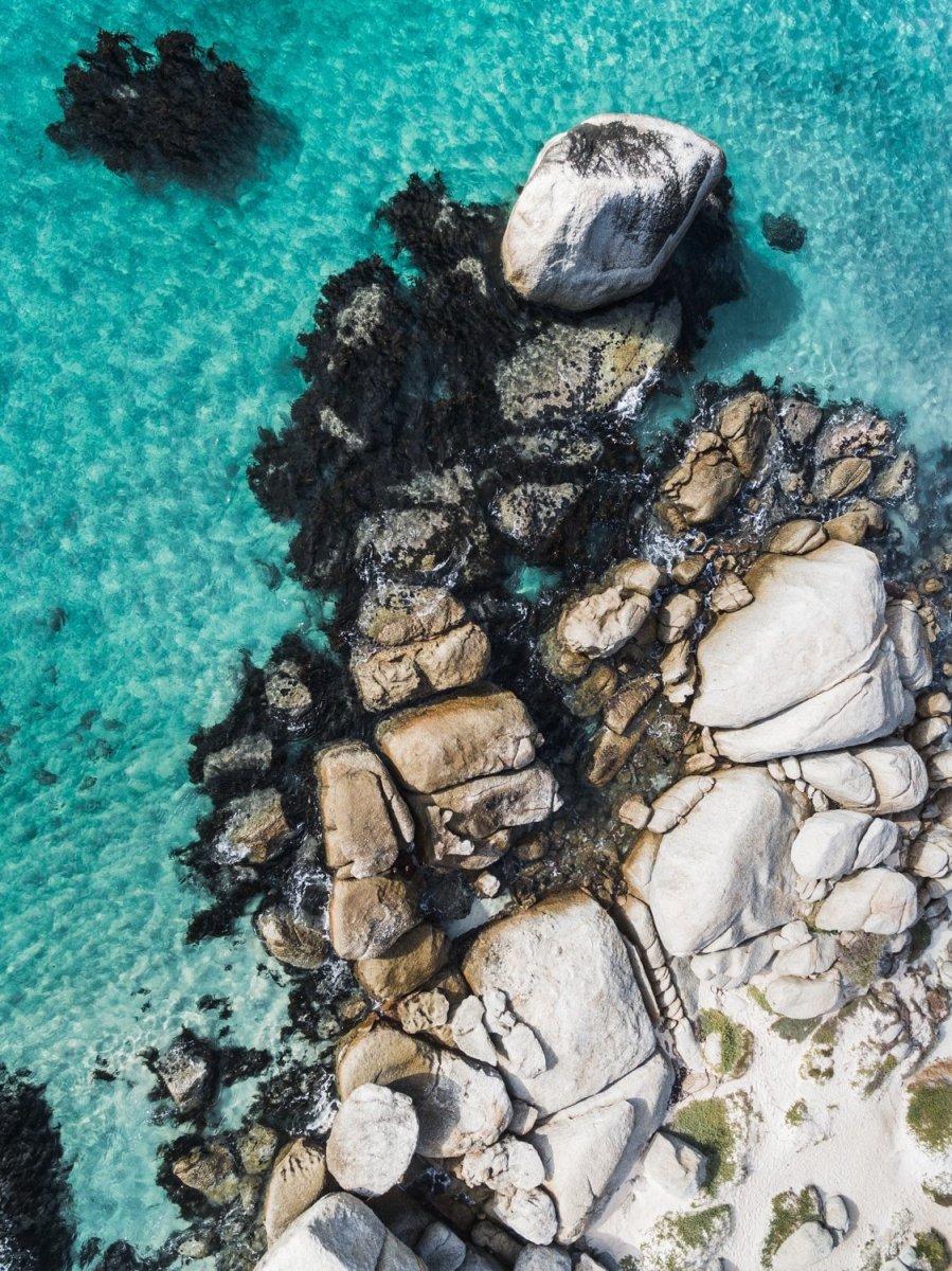 Aerial of boulders and blue sea along the coast of Simons Town