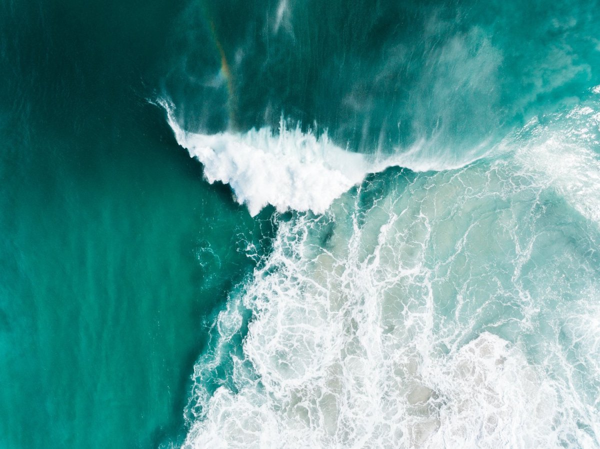 Big whitewash turquoise wave breaking with rainbow at Noordhoek Beach Cape Town