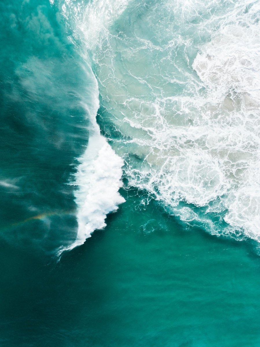 Big whitewash turquoise wave breaking with rainbow at Noordhoek Beach Cape Town