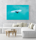 Aerial of girl holding striped surfboard in blue water in Camps Bay Beach in a white fine art frame