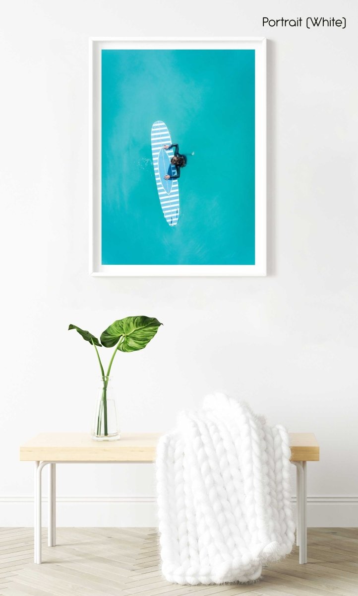 Aerial of girl holding striped surfboard in blue water in Camps Bay Beach in a white fine art frame