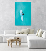 Aerial of girl holding striped surfboard in blue water in Camps Bay Beach in a natural fine art frame