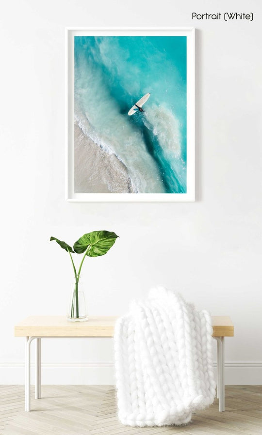 Girl walking back to shore with surfboard in blue water and waves in a white fine art frame