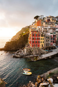Docked boats and colorful buildings at sunset in Riomaggiore Cinque Terre