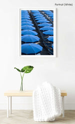 Blue umbrellas and beach chairs lined up in Italy in a white fine art frame