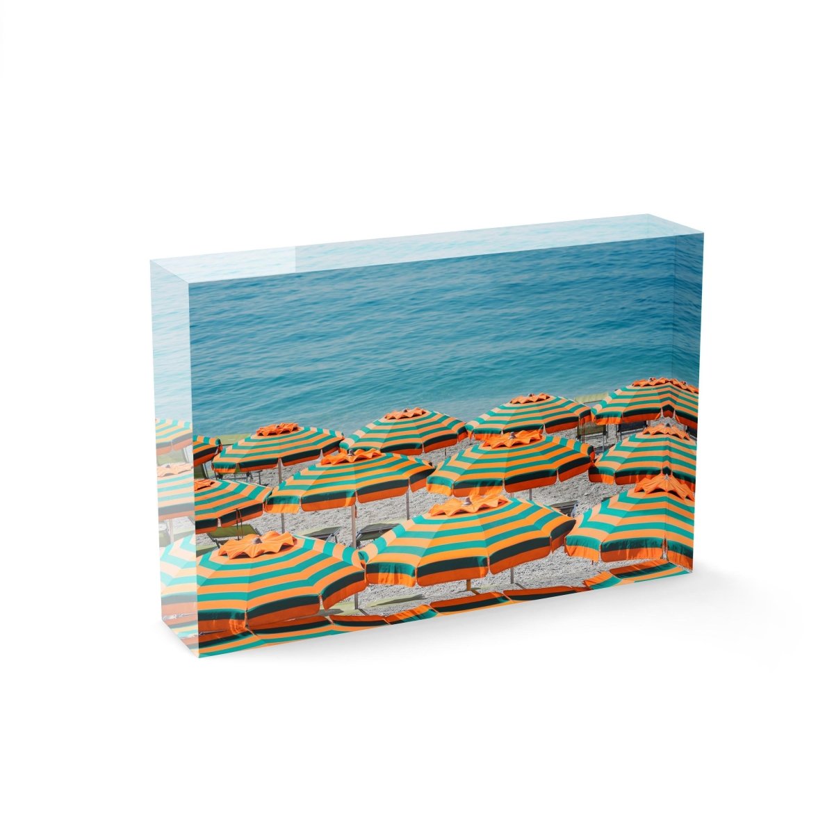 Rows of striped orange umbrellas and turquoise sea in Cinque Terre