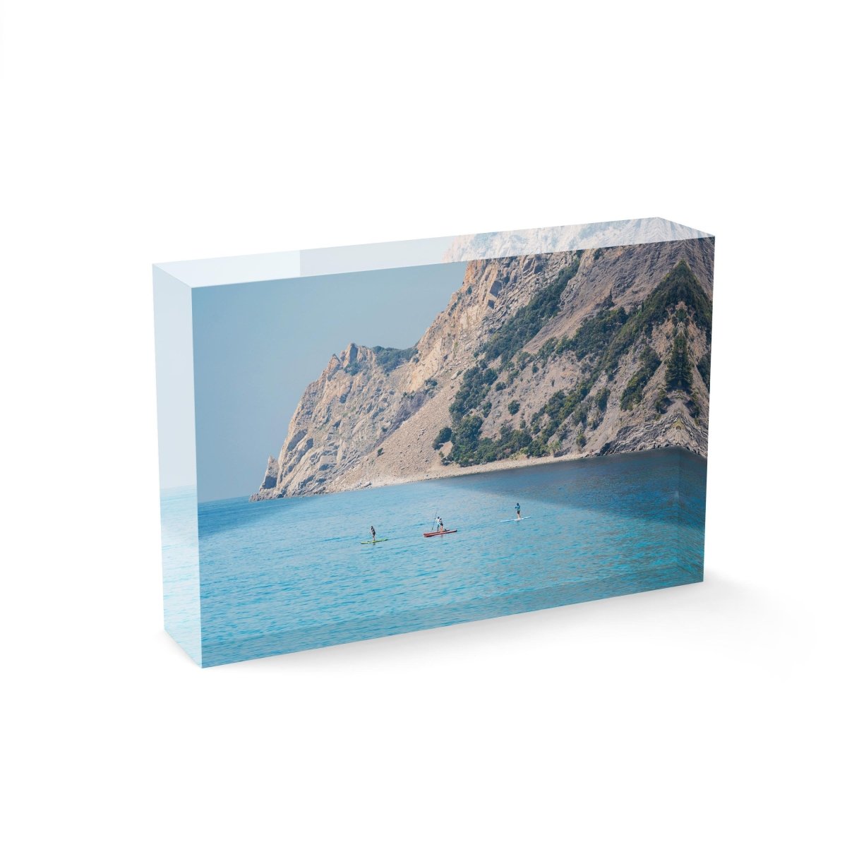 Four people paddling on board alongside mountains in Cinque Terre