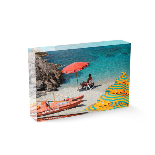 Italian lifeguard sitting under umbrella at blue water on Monterosso Beach