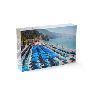 Rows of blue umbrellas along blue mediterranean sea in Cinque Terre