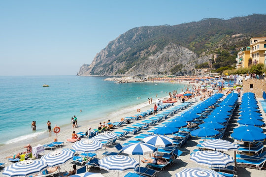 People and umbrellas at Monterosso beach Cinque Terre during summer