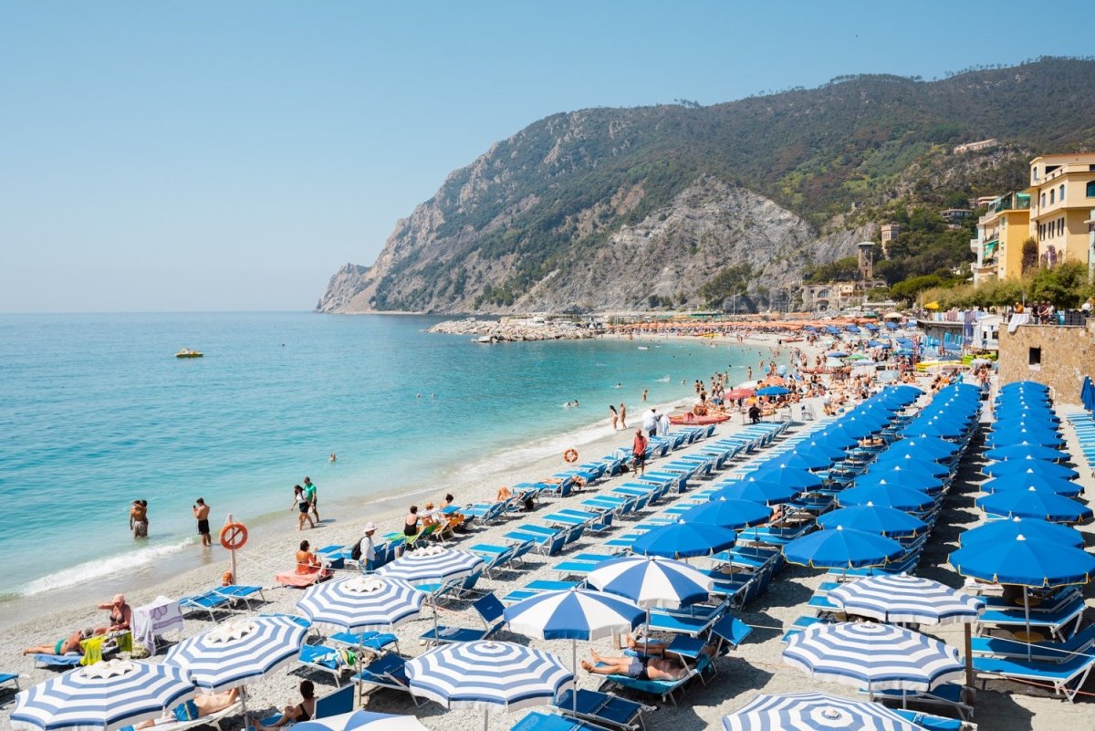 People and umbrellas at Monterosso beach Cinque Terre during summer