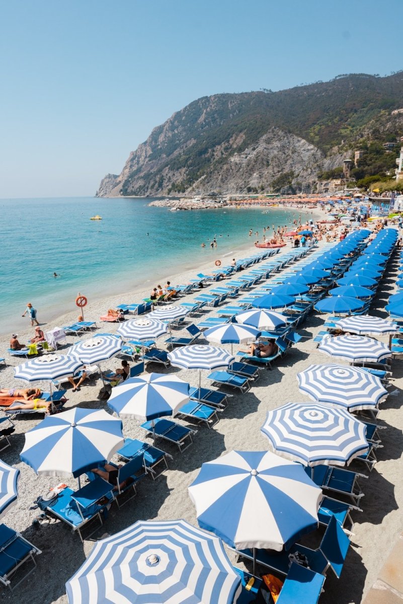 People and umbrellas at Monterosso beach Cinque Terre during June