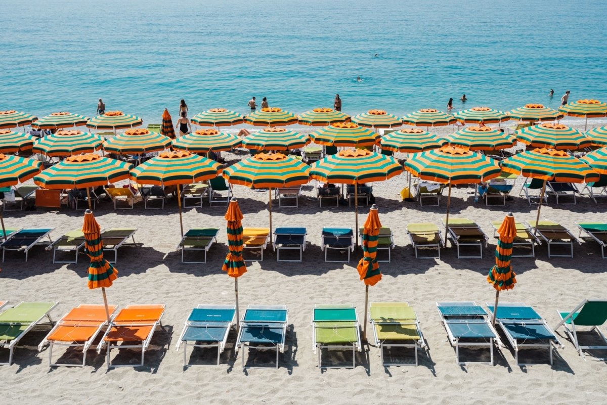 Orange, green and blue colors of umbrellas and sea in Cinque Terre