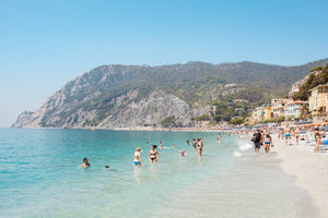 Hot sunny day with people swimming at Monterosso beach Italy