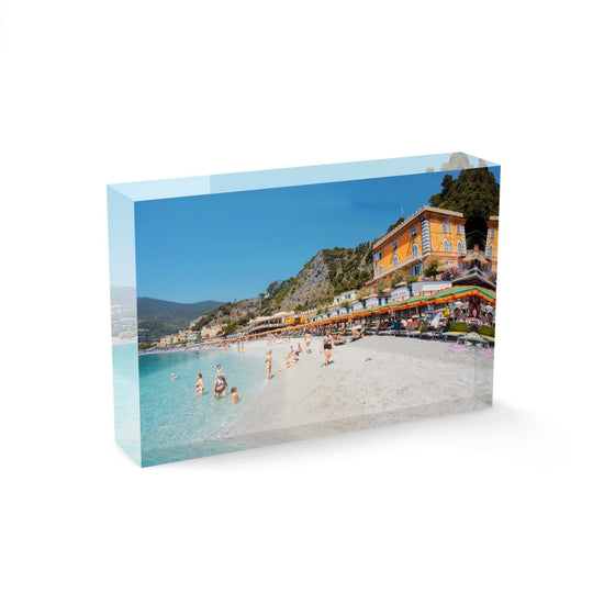 People swimming and sitting at colorful Monterosso beach in Italy