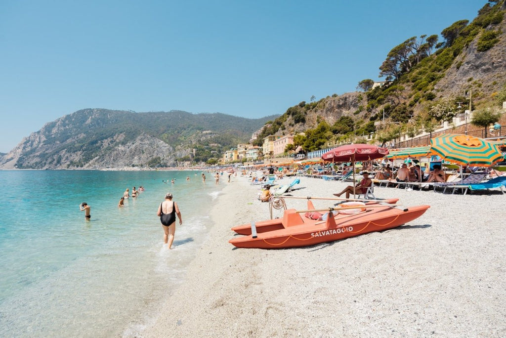 Italian vibes along Monterosso beach with people swimming and lying at water