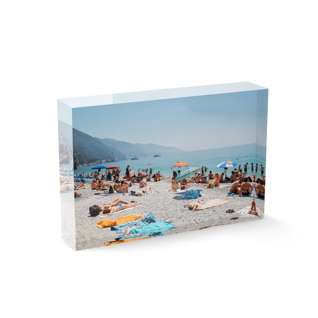 People lying on towels in the sun on Monterosso beach in Cinque Terre