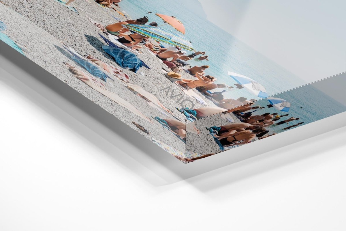 People lying on towels in the sun on Monterosso beach in Cinque Terre in an acrylic/perspex frame