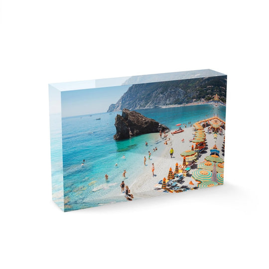 Big rock on Monterosso beach surrounded by people and blue water Cinque Terre