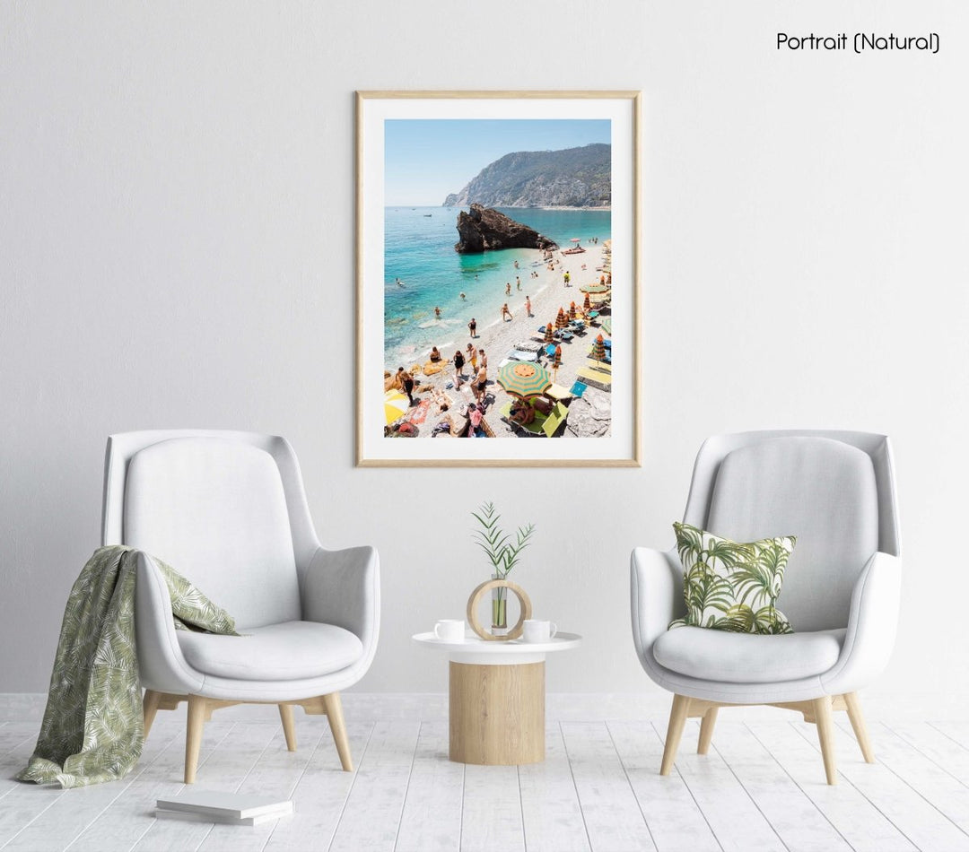 Big rock on Monterosso beach surrounded by people and blue water in Italy in a natural fine art frame